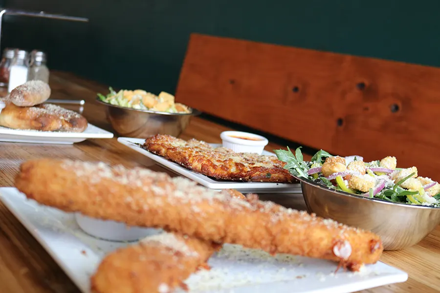 a plethora of delicious-looking fried foods spread across a wooden table.